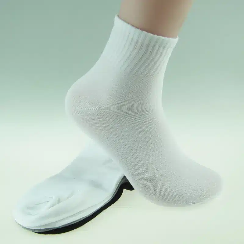 valged kõrged meeste sokid, üks paar jalas ja teine paar maas