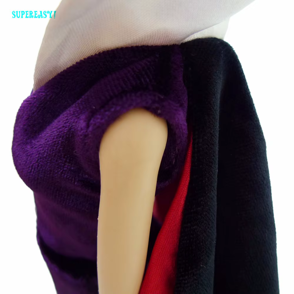 lilla kleit ja must keeb Barbie nuku seljas