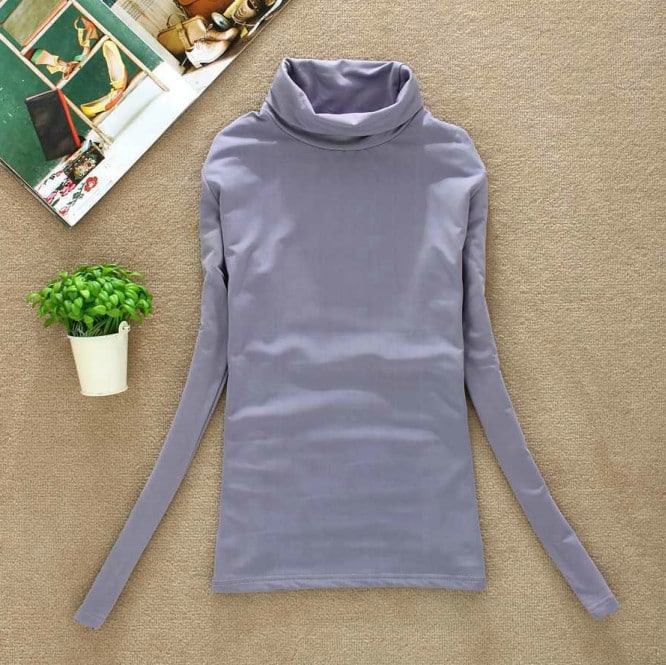 helelilla kõrge kraega pehme pullover, mis on asetatud beežile taustale
