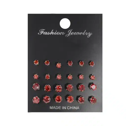 Erinevad kõrvarõngaste komplektid sisaldavad erineva suurusega punaseid kivikesi, mis on paigutatud mustale kaardile.