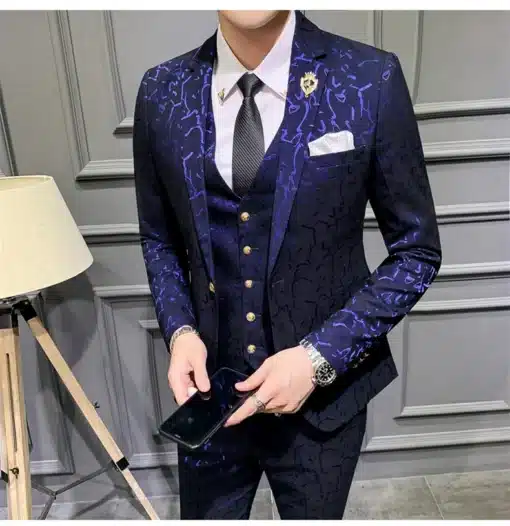 Tumepunane mustriline ülikond elegantsete kuldnööpidega, sobib ideaalselt hallil taustal.