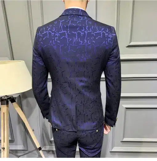 Tumepunane mustriline ülikond, mille seljal on elegantne mustriga kangas ja luksuslik läige, hallil taustal kaunistamas mehe figuuri. Stiilne välimus rõhutab detailide jõudu.