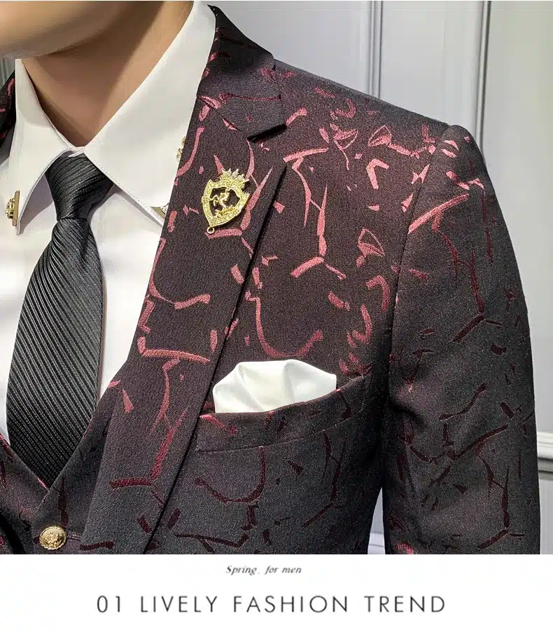 Tumepunane mustriline ülikond lähedalt vaadatuna, näidates elegantset mustrit ja kvaliteetset kangast koos valge triiksärgi ning musta lipsuga taustal.