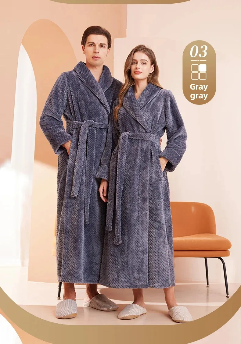 Kahe täiskasvanu hallid flanellist hommikumantlid, mis on esiplaanil koos pehmete sussidega, asetatud elegantse ja kaasaegse interjööri taustal.