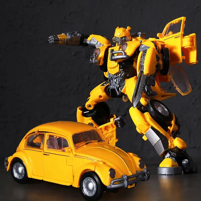 Pildil on Transformeeruv Transformer Bumblebee, kollane robot, kes seisab kollase auto järel, valmis tegevuseks. Robot on detailne ja futuristliku disainiga, hallide ja mustade elementidega, väljendades masina ja inimkuju kombinatsiooni tumedal taustal.