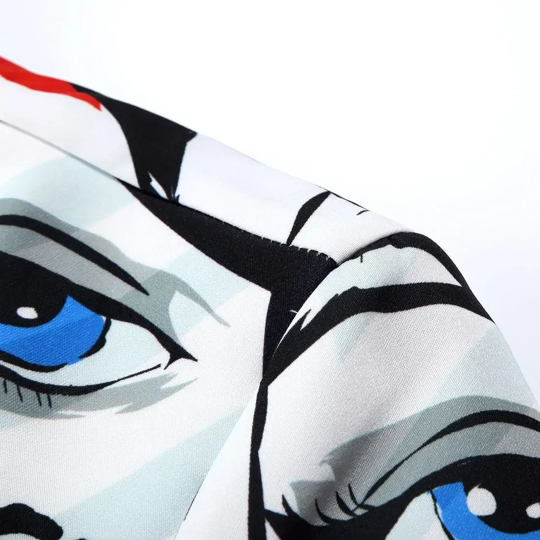 Lähivõte meeste pintsakust, millel on silmapaistev must-valge näokunsti kujundus koos erksiniste silmade detailidega. Pintsakul on pehme ja sile materjal, mis annab rõivale elegantse ja unikaalse välimuse.