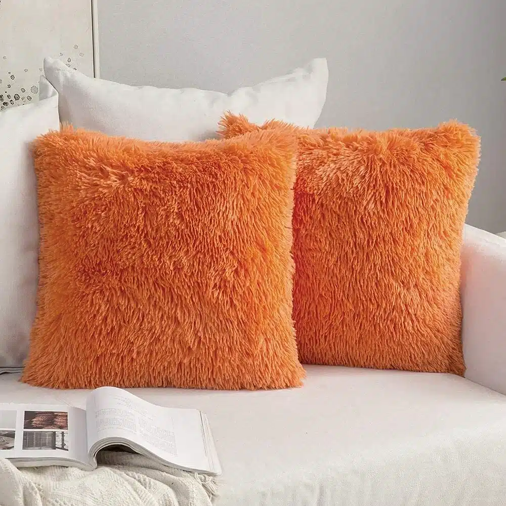 kaks oranži karvast padjakatet valgel diivanil