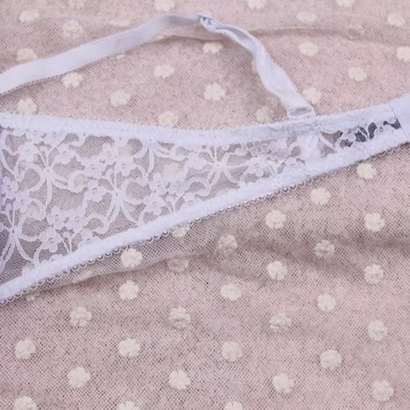 Elegantne Väikeste kristallidega pesukomplekt, mille pitsiline detail ja õhkõrn kangas loovad naiseliku ja peene välimuse beežil taustal.