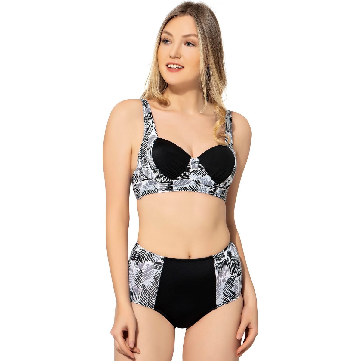 Model wearing black and white form-fitting push-up bikini with leaf pattern, featuring supportive straps and high-waisted bottoms.