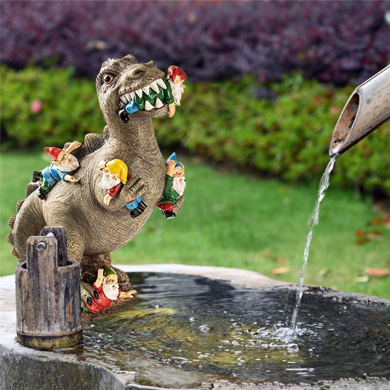 Kuju dinosauruse ja pöialpoistega, millel on kivist tekstuur ja mitmevärvilised pöialpoisid, on asetatud rohelise muru tausta vastu ning illustratsioonina voolab vett lähistel asuvasse anumasse.