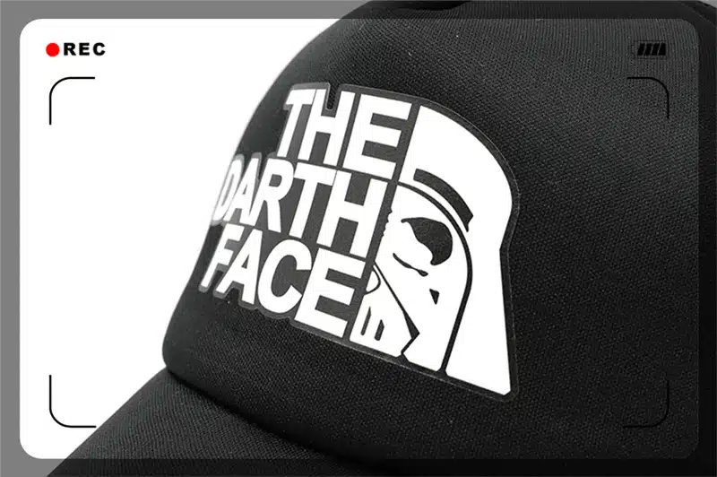 must nokamüts valge trükiga, millel on sõnad 'the darth face' ja kiivri kujutis
