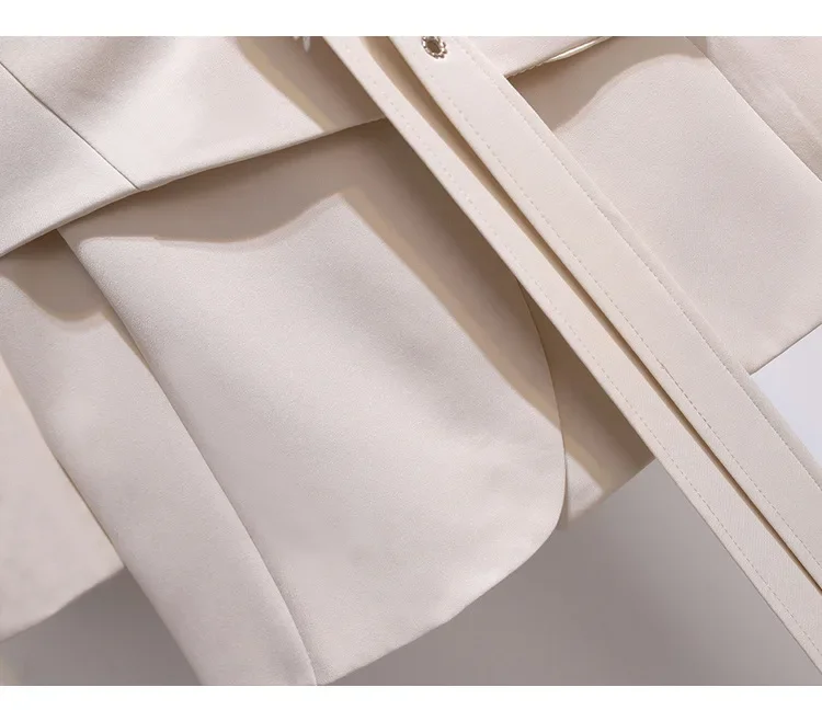 Lähivaade beežist pintsakkleidist, esile tõstetud detailse õmblustöö ja elegantse disainiga, sobilik pidulikeks sündmusteks.