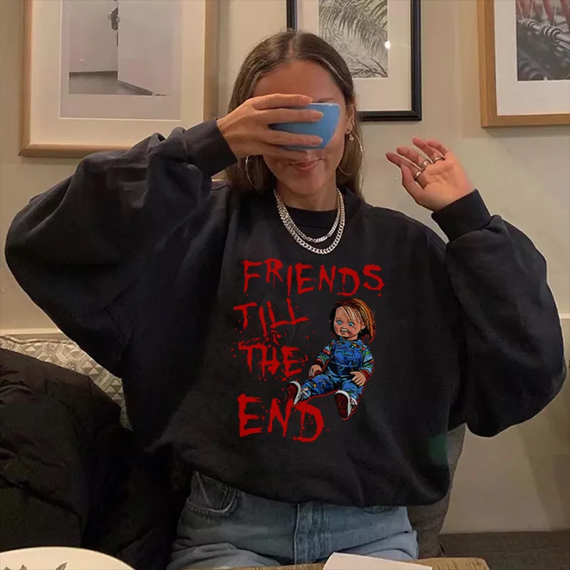 naine istub kohvikus, kandes musta pusa punase kirjaga 'friends till the end'