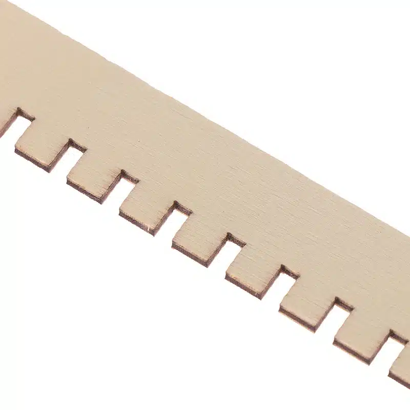 Lähivõte puidust laste kangastelgede osast, näidates hoolikalt viimistletud siledat pinda ja sakilist serva.