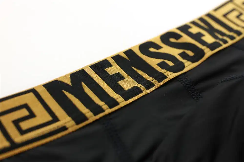 mustad meeste stringid kuldse mustriga vööosal