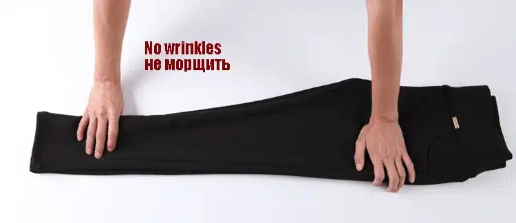 mustad soojad voodriga naiste retuusid laual, kaks kätt neid silumas