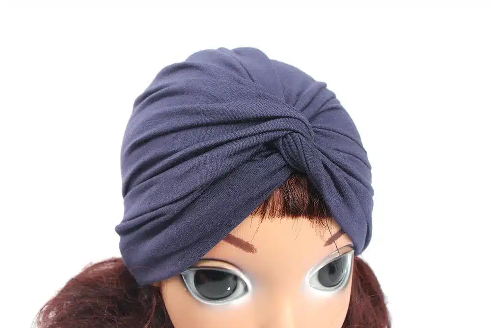 tumesinine laste turbanmüts mannekeeni peas, sõlm ees