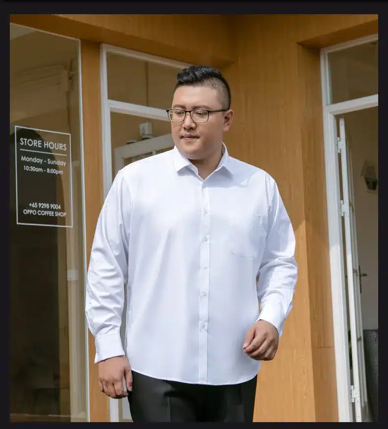 mees kannab valget triiksärki ja musti pükse, seistes kohviku ees
