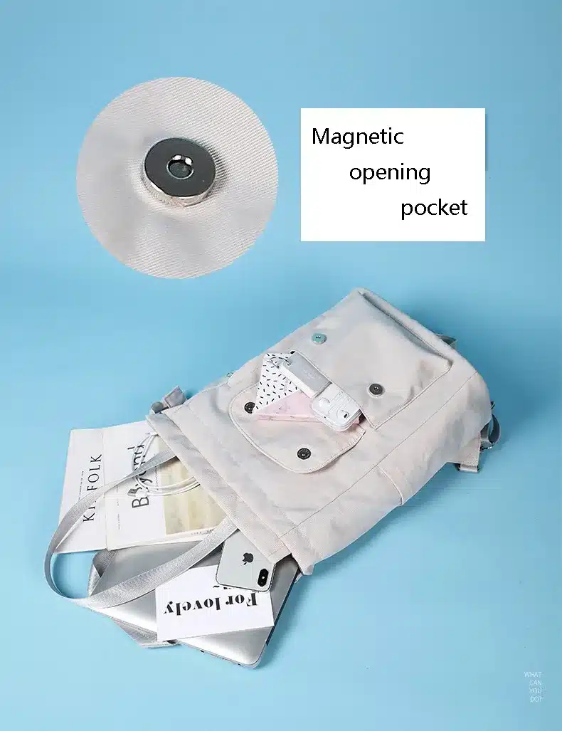 valge seljakott magnetkinnitusega, mille sees on raamatud ja elektroonikaseadmed