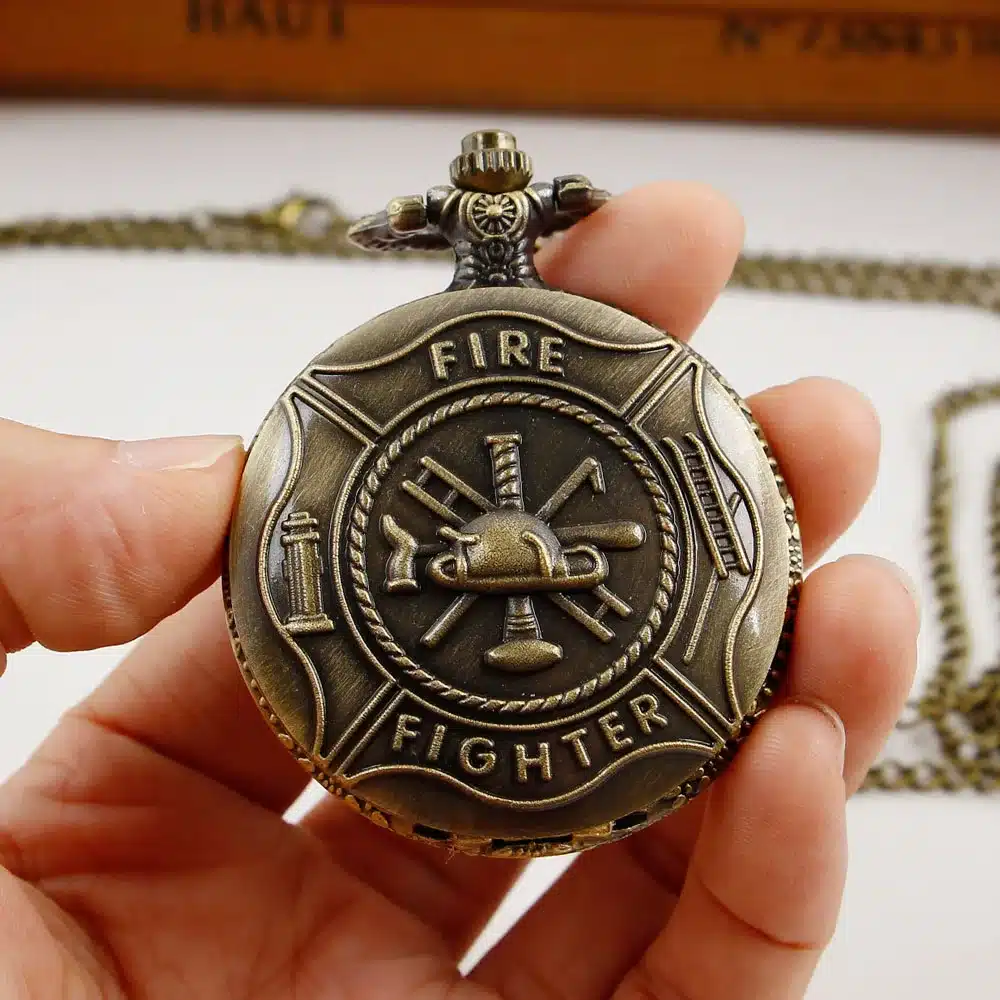 pronksikarva taskukell, mille esiküljel on kiri 'Fire Fighter' ja tuletõrje sümbolid