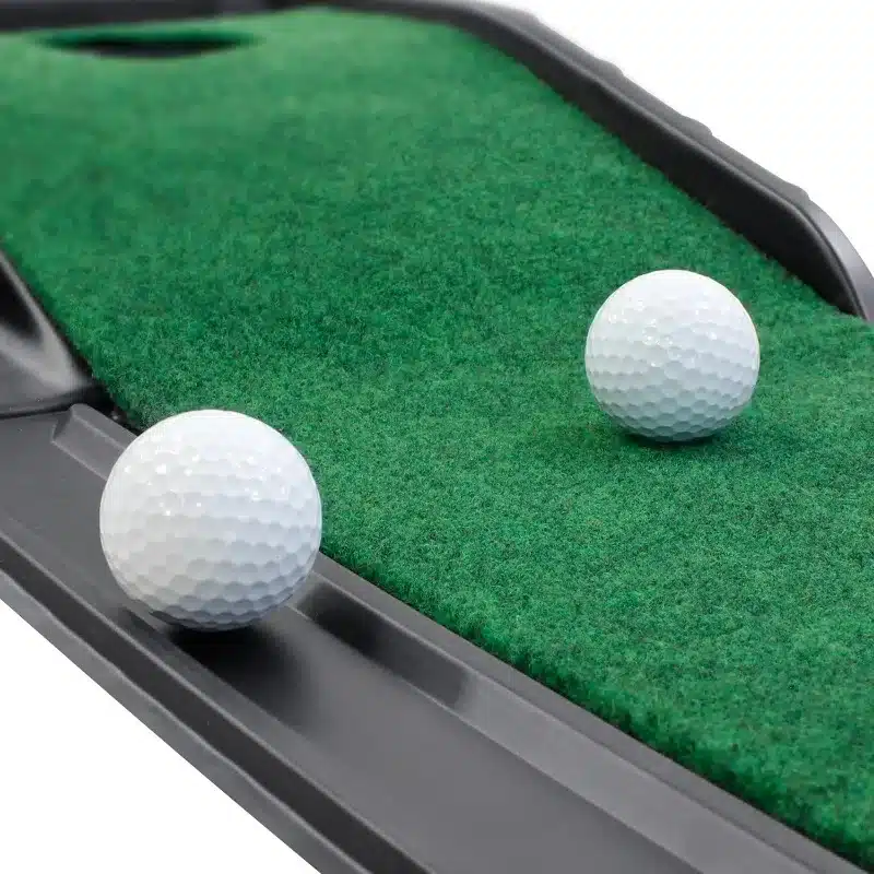 kaks valget golfipalli rohelisel kunstmurul
