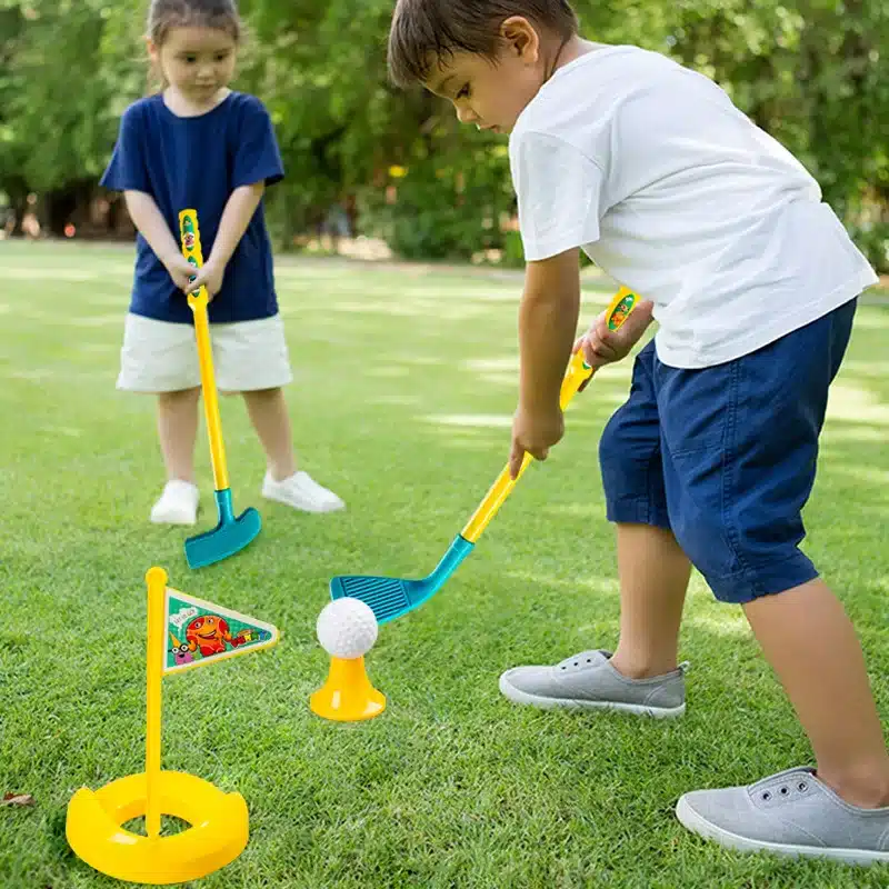 kaks last mängivad murul värviliste golfikeppidega