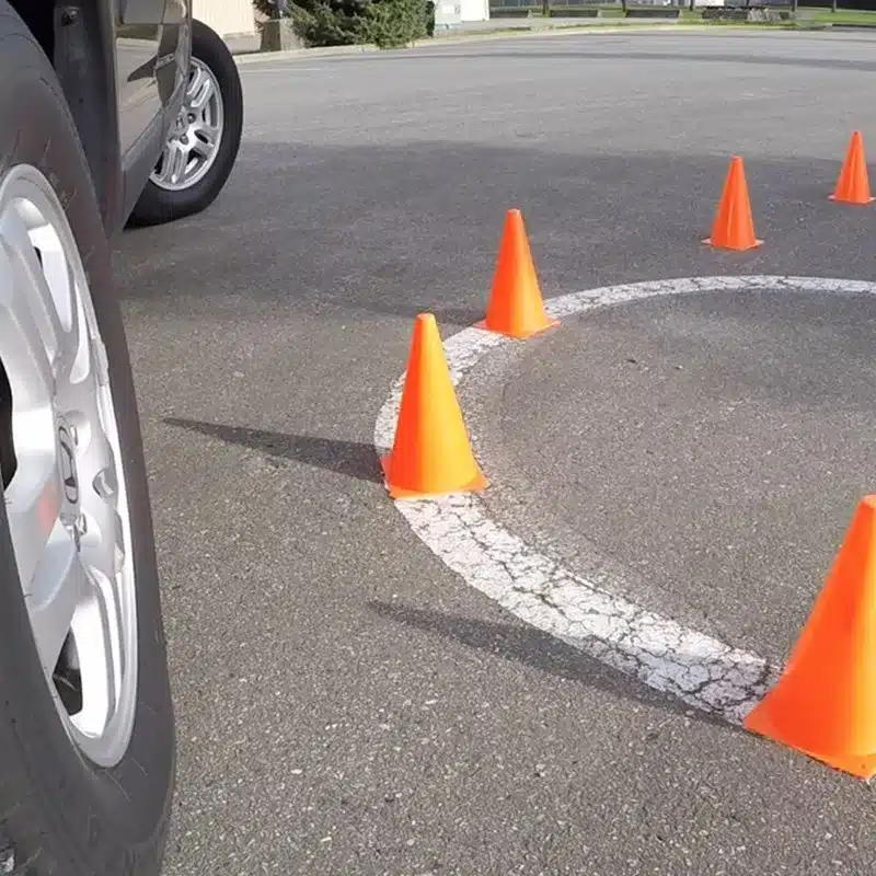 oranžid koonused asfaldil, auto lähedal
