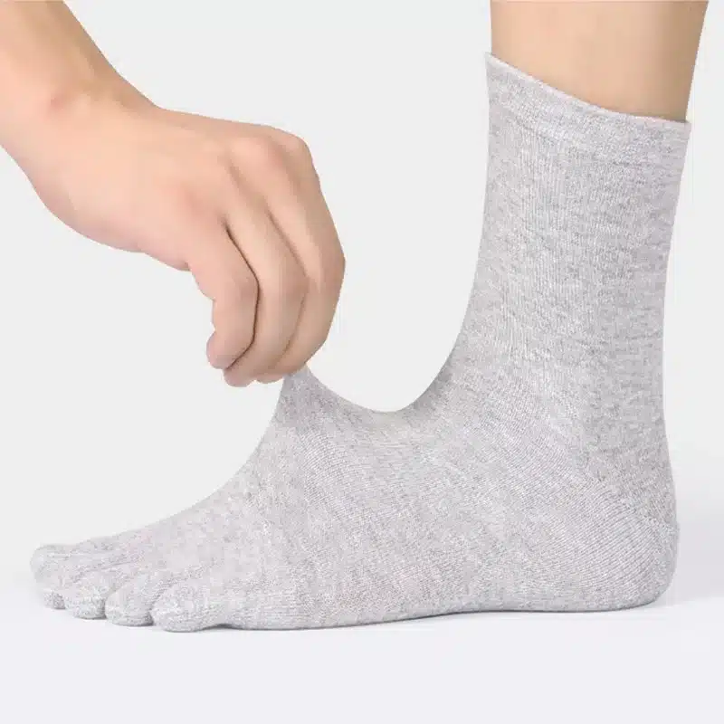 hallid meeste varvassokid jalas, käsi tõmbab sokki