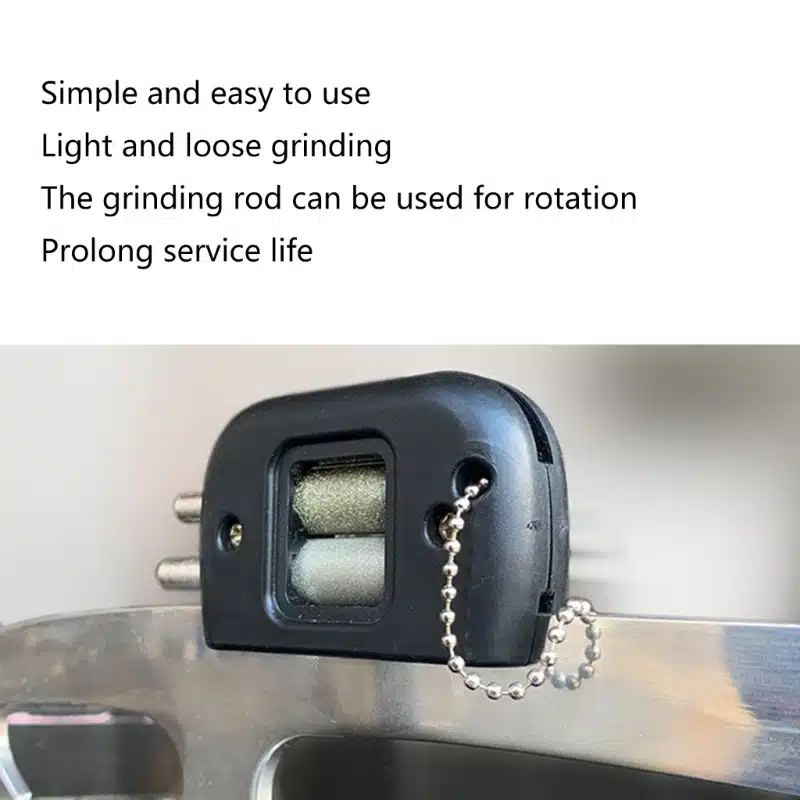 Uisuteritaja koos metallist teritusdetailidega, must korpus ja hõbedane kett metallist pinnal.