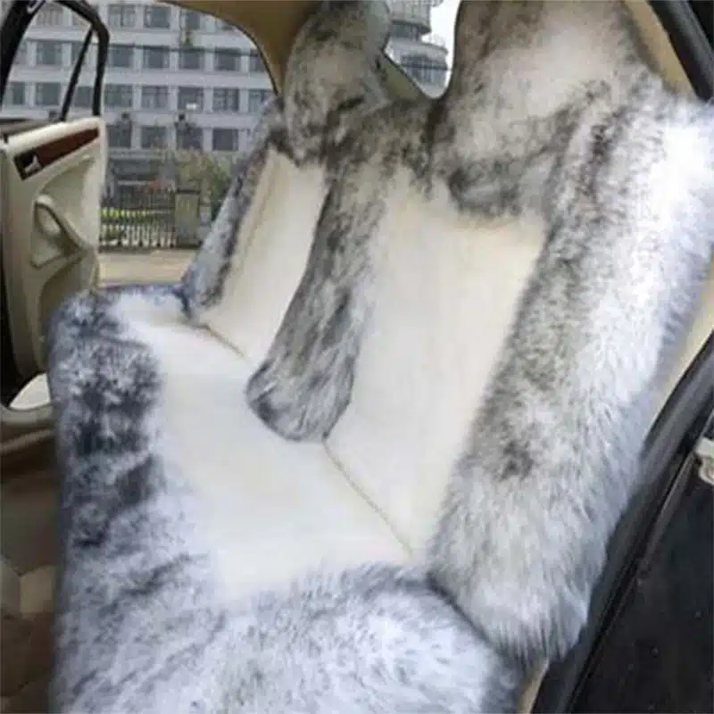 Auto tagaistmel luksuslik Austraalia lambanahast istmekate, millel on pehmed hallikad toonid ja elegantne viimistlus, pakkudes reisijatele hubast ja stiilset kogemust.