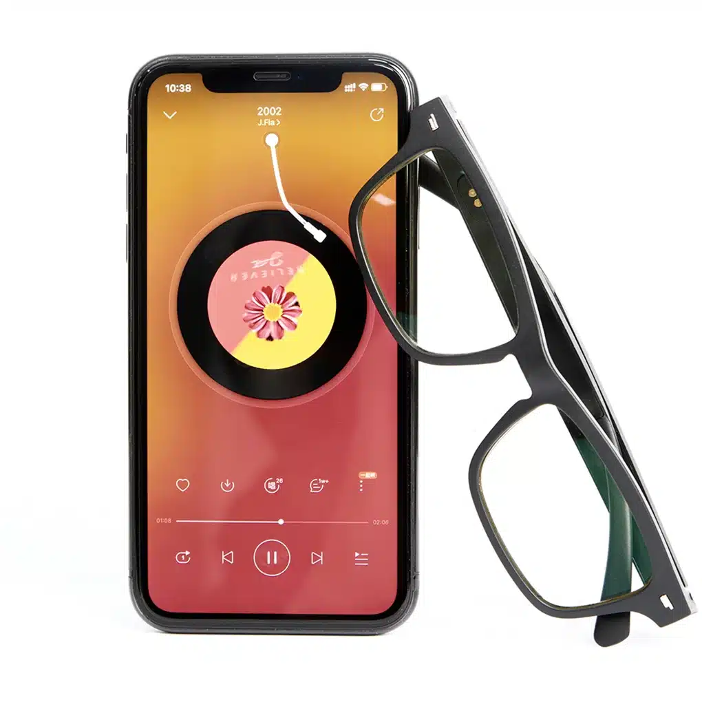 mustad bluetooth nutiprillid nutitelefoni kõrval, mille ekraanil on muusikarakendus