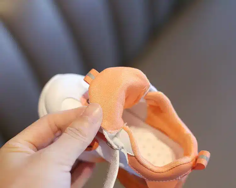oranži ja valgega laste toss, mida hoitakse käes