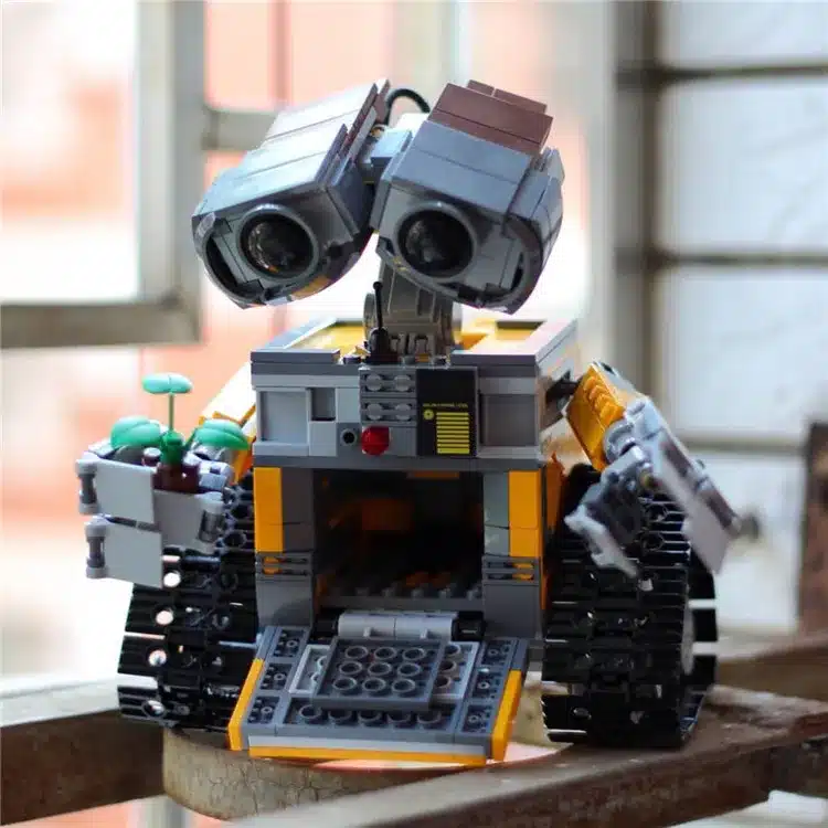 kollane ja hall robot mänguasja kujul, millel on liikuvad roomikud ja suured silmad