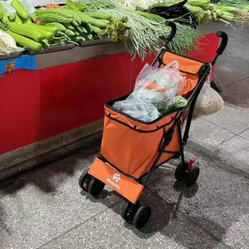 oranž kokkupandav ostukäru turul, täidetud toidukaupadega