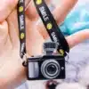 miniatuurne must mängukaamera naeratava näoga rihmaga