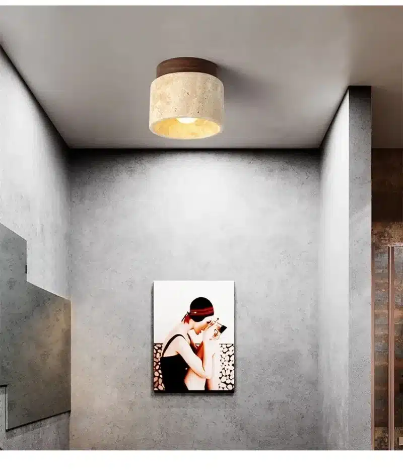 laes ripub kivist ja puidust lamp, mille all on hall sein ja kunstiteos