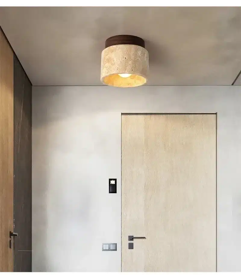 laes olev kivist ja puidust lamp neutraalsete seinte ja ukse kohal