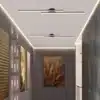 kahe minimalistliku led valgustiga koridor, millel on tumedad seinad ja kunstiteosed