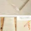 Beige puidumustriga iseliimuv tapeet rullina, millel on näha puidutekstuur ja pehme läige, sobib mööbli ja seinte dekoreerimiseks.