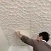 Üksikisik paigaldab 3D veekindlat lae- ja seinakleebist beeži geomeetrilise mustriga lakke.