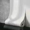 Valge linane 3D tekstuuriga iseliimuv paks tapeet, paigaldatud modernse betoonseina taustale, rõhutades selle elegantset ja ainulaadset tekstuuri.