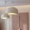 Kaks Skandinaavia stiilis LED laelampi, millel on minimalistlik kuppel ja peen valge toon, valgustavad hubaselt modernset interjööri beige taustal.
