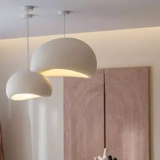 Kaks Skandinaavia stiilis LED laelampi, millel on minimalistlik kuppel ja peen valge toon, valgustavad hubaselt modernset interjööri beige taustal.
