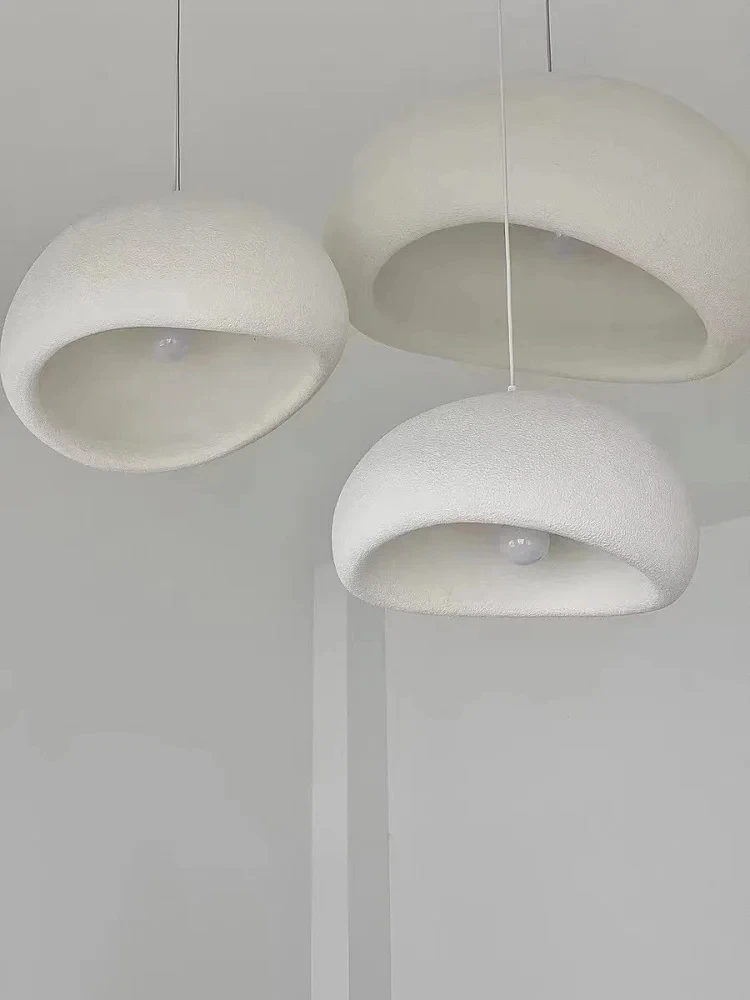 Kolm valget, minimalistlikku Skandinaavia stiilis LED laelampi, rippuvad valguses neutraalsel taustal.