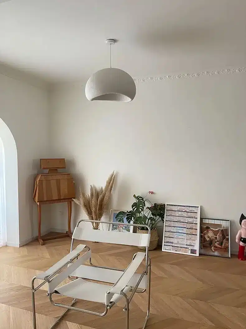 Valgesse sisekujundusega toas ripub lage valgustamas Skandinaavia stiilis LED laelamp, mis lisab puhtust ja elegantsi ruumi helehallide toonidega.