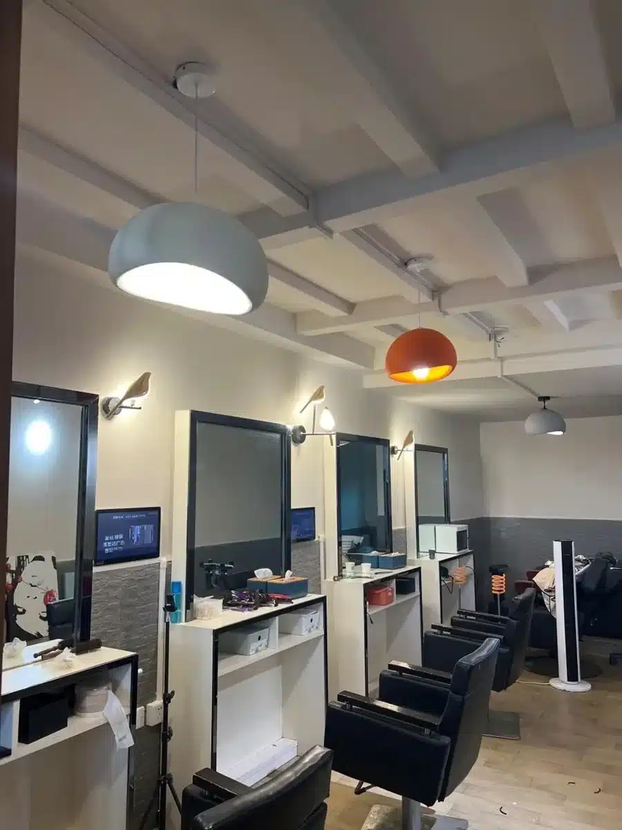 Modernne salongiinterjöör, kus on näha Skandinaavia stiilis LED laelambid, mis valgustavad ruumi pehme ja sooja valgusega. Laelambid on modernsed ning sobivad valge ja oranži värviga kaasaegse kujundusega.