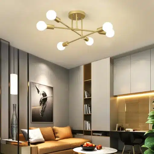 Kuldne Moodsad 6 pirniga laelamp elegantse disainiga, paigaldatud kaasaegsesse elutuppa, kus on beež diivan, kunstiteos seinal ja kaasaegne mööbel.