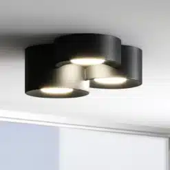 Kolme ümmarguse musta metallist Skandinaavia disainiga LED laelambi installatsioon, millel on kaasaegne ja stiilne välimus, valgustades valget lage.