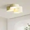 Kolmeosaline Skandinaavia disainiga LED laelamp, paigaldatud heledale ruumi lakke. Lambid on valmistatud kreemjas toonis metallist, rõhutades minimalistlikku ja elegantset esteetikat.