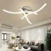 Kaasaegsed ja ökonoomsed LED valgustid, mis on paigaldatud elutoa lakke, näidates ruumis heledat ja stiilset valgust. Valgustite futuristlik disain koosneb mitmest kumavast ribast, mis loovad sujuva valge valguse, sobitudes suurepäraselt kaasaegse interjööriga.